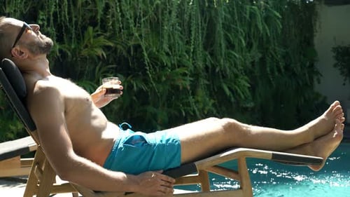 Man Relaxing Poolside Drinking Refreshing Beverage