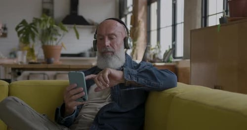 Man Relaxing with Music and Smartphone at Home