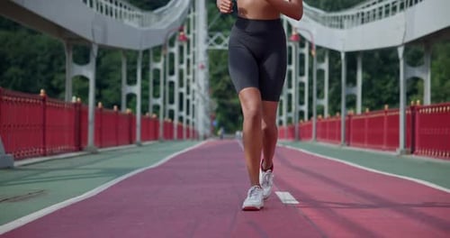 Young African American Woman Runner Jogging on City Bridge Outdoors