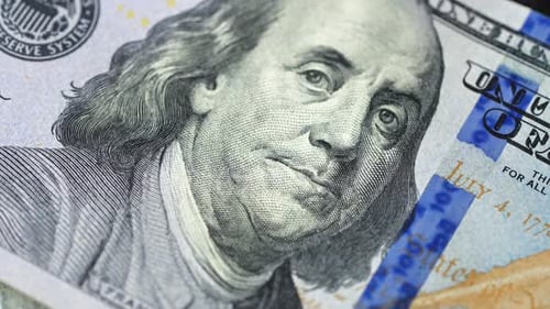 Examen rapproché de billets de cent dollars américains présentant leurs caractéristiques