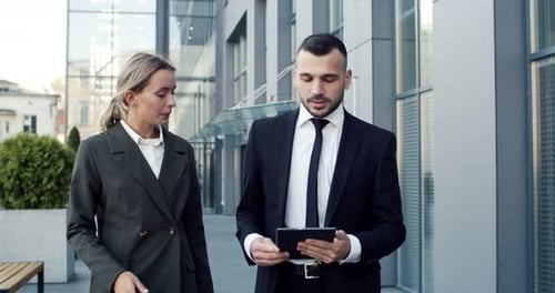 Caucasian Businesspeople Chatting at the Street with Each Other Man Demonstrating Something on the