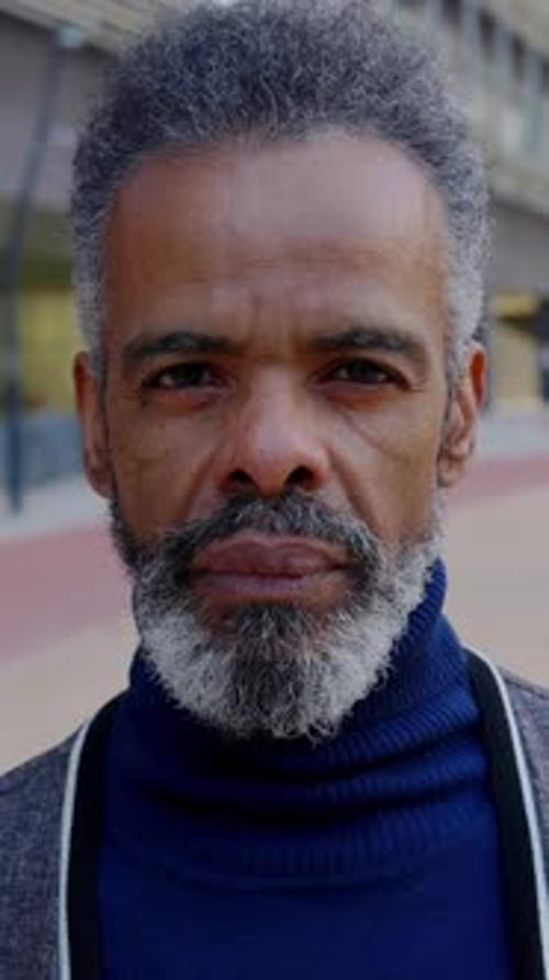 Senior Brazilian Man Looking at Camera Standing Outside at Urban City Area