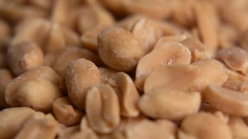 Salted peanuts snack food on the table. Track in background. Salted and roasted peanuts seeds.
