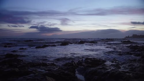 Ocean waves during twilight at a rocky beach