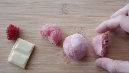 Close-up of strawberry and white mochi with raspberry and pieces