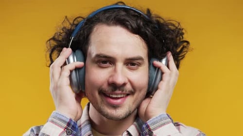 Young Adult Smiles with Headphones On
