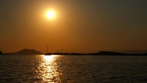 Sunset Ocean View with Sailboat Silhouette