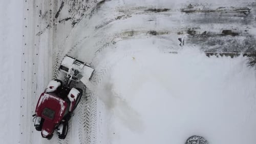Snowplow tractor clearing snowy road in St-Constant, winter maintenance, birds eye view