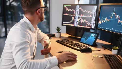 Checking some graphs. Stock broker in formal clothes is working indoors in the office