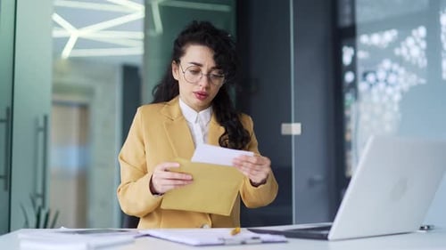 Woman Reviews Documents at Her Office Desk