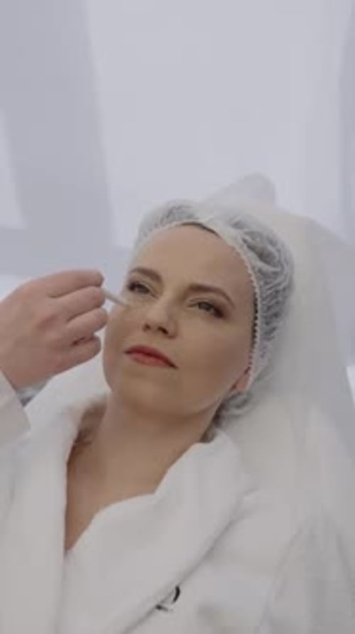 Cosmetologist Applying Makeup to Woman's Face