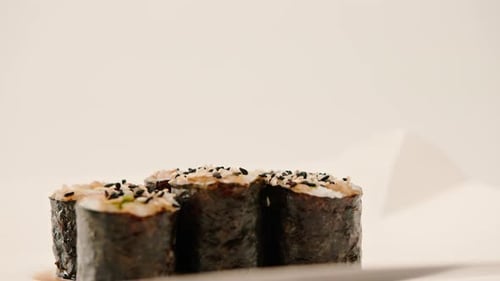 Close-up of maki roll with avocado with soy sauce in sushi delivery box on white background