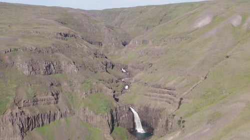 Spectacular volcanic mountainous river flowing with waterfall in Iceland, Bessastaðargil