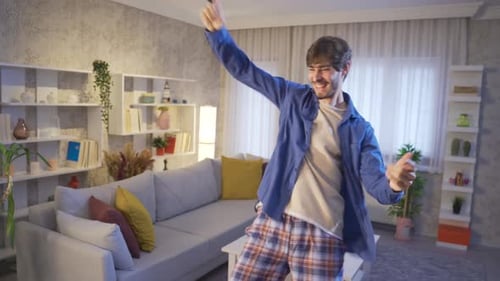 Funny young man dancing and having fun at home.