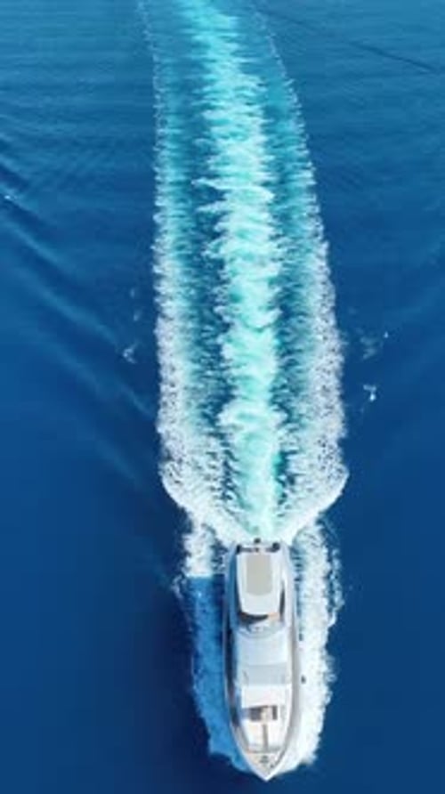 Vertical aerial view of gulet on clear water