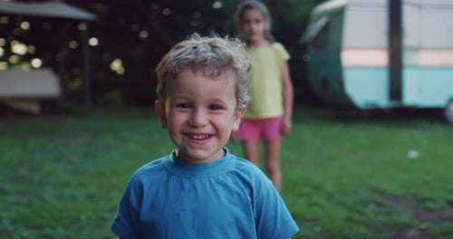 Boy Smiling in Yard Near Camper