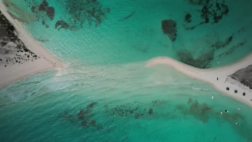 A turquoise lagoon with sandy isthmus and clear waters, aerial view