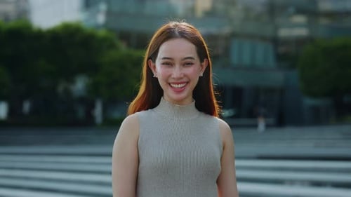 Portrait of Young Asian Female in Dress Smiles As Stands on City Square