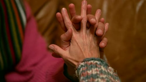 Two Intertwined Hands One in Warm Gloves Create a Feeling of Closeness and Support The Background