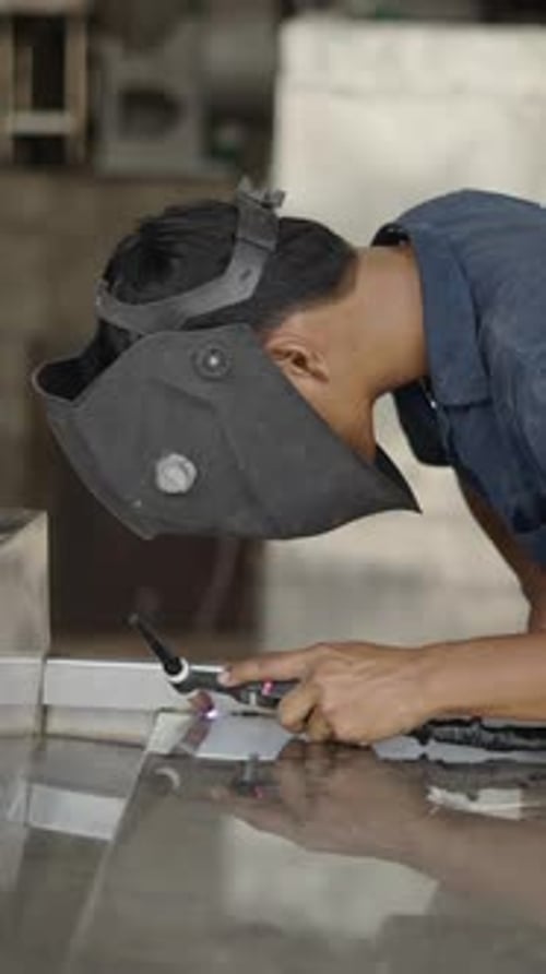 Middle Shot of a Young Laborer Welding Two Metal Pieces FHD Vertical Video