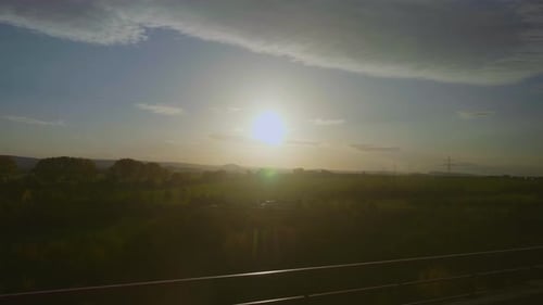 Blick auf die Passagiere aus dem Zug mit Blick auf den Sonnenuntergang und die grünen Felder während der Schnellbahnfahrt