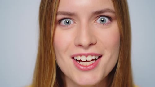 Surprised young woman looks directly at the camera