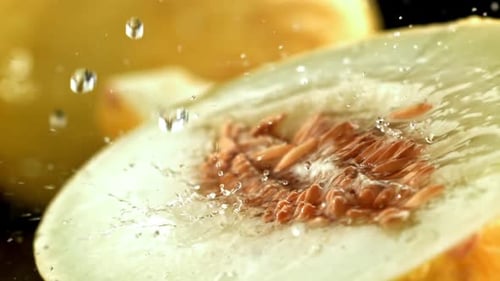 Des gouttes d'eau tombent sur un melon frais filmées par une caméra haute vitesse à 1000 images par seconde