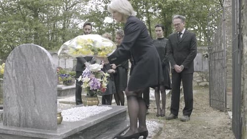 Mourning Family at a Cemetery During the Daytime