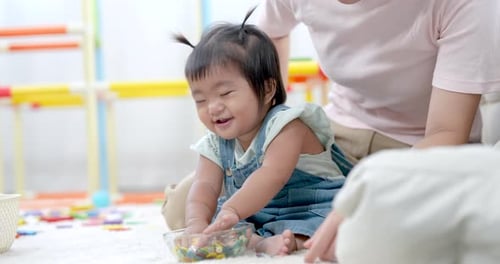 Adorable Infant Playing with Colorful Toys at Home