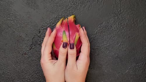 Halved Dragon Fruit on Dark Textured Surface