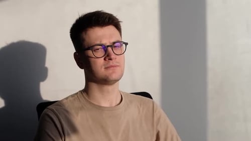 Retrato de hombre de negocios inteligente con gafas sentado en el escritorio de trabajo en una oficina moderna mirando
