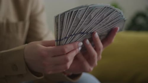 Orbiting Around Woman Holding Money In 100 Dollar Bill