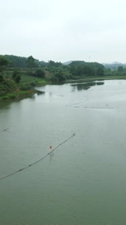 Grande rivière au Vietnam avec de nombreux bateaux de pêche entre les montagnes et la végétation