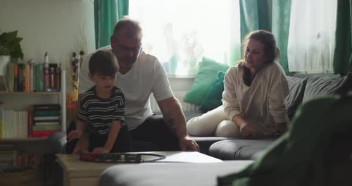 Family Playing with Toy Train in Living Room