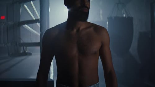Young African American Boxer with Bare Chest in Shorts and Gloves