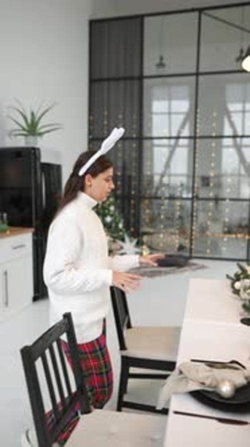 Young Woman Setting New Year's Table at Living Room