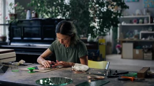 in a Large Green Workshop a Woman with Green Hair Creates Decorative Flowers Laying Them Out on a