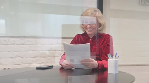 Senior Woman Reading a Document with Satisfaction
