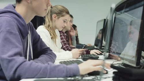 Mädchen und Junge im Teenageralter arbeiten im Technologieunterricht am Computer