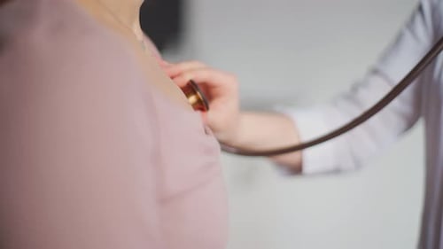 Doctor Listens to Patient Heartbeat with Stethoscope