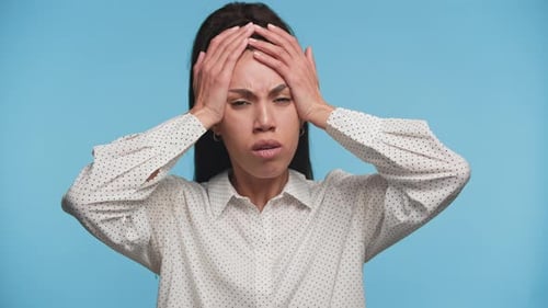 Worried Woman Holds Her Head in Concern