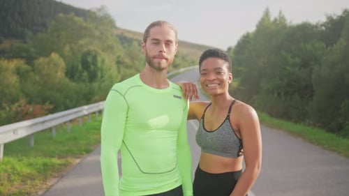 Happy Runners Posing By Countryside Roadside Two Exercise Partners Basking in Bright Sunlight Amidst
