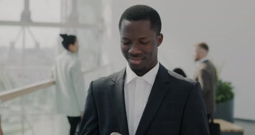 Happy Entrepreneur Walking in Office Building Using Smartphone Smiling Enjoying Successful Career