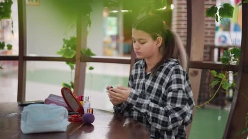 Teen Girl Applying Makeup in Shopping Mall