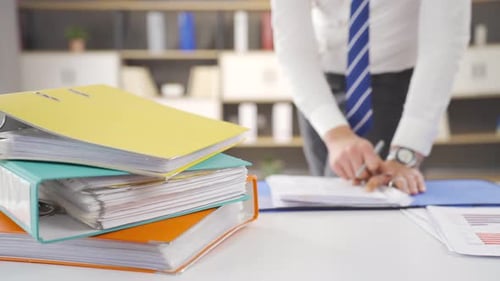 Professional Man Signing Documents at His Office Desk