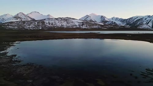 Twilight lake, snowy mountain view, peaceful alpine scene, aerial