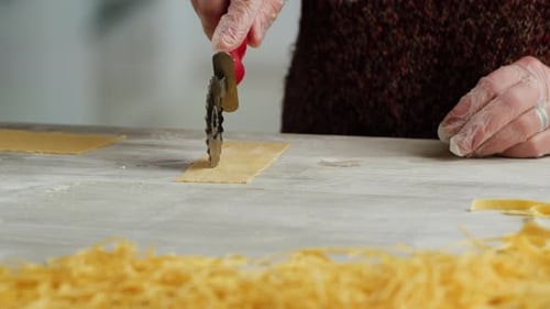 Woman Using Pasta Machine to Make Fresh Pasta Dough in the Kitchen Cooking in Italian Restaurant