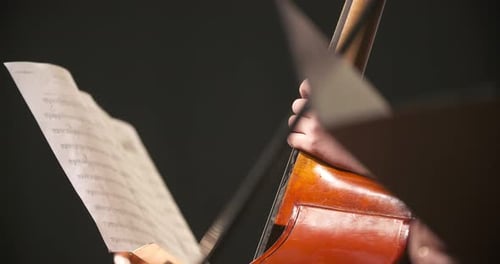 Cellist Holding Cello and Looking at Sheet Music