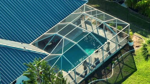 Typischer zeitgenössischer amerikanischer großer Swimmingpool im Hinterhof eines Privathauses mit Außenterrasse