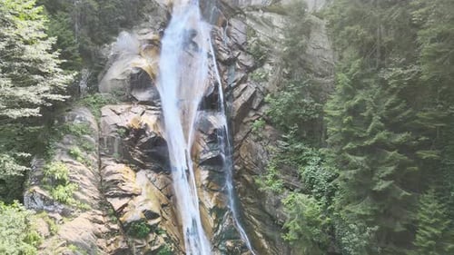 Majestic Waterfall Cascades Through Lush Green Forest